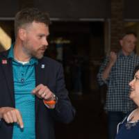 Three people talking in business-casual wear at event